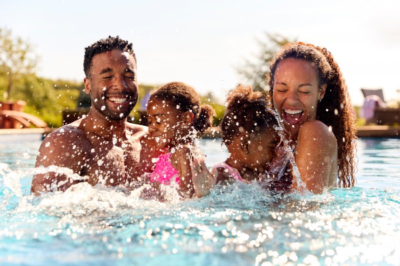 Family enjoying the pool after cosmetic dentistry